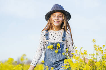 Cute girl wearing sun hat standing in agricultural field - JCMF01959