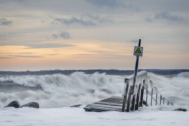 Riverside jetty during storm at winter dusk - KEBF01864