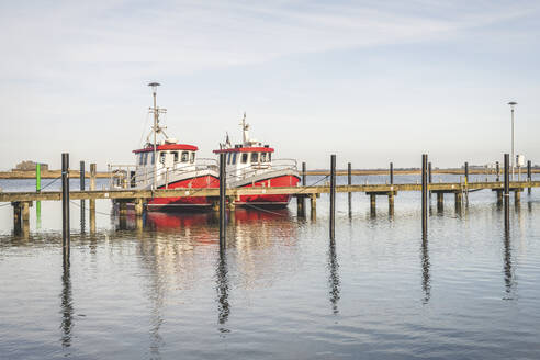 Deutschland, Schleswig-Holstein, Heiligenhafen, Zwei Fischerboote nebeneinander im Stadthafen vertäut - KEBF01868