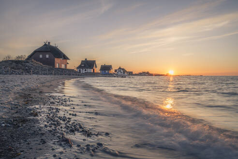 Deutschland, Schleswig-Holstein, Heiligenhafen, Strandvillen am Ufer der Graswarder Landzunge bei Sonnenuntergang - KEBF01869