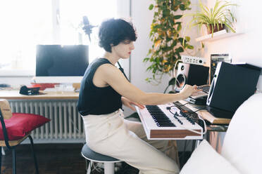 Female musician playing piano at studio - DGOF02146