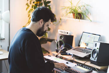 Male music composer using piano in studio - DGOF02175