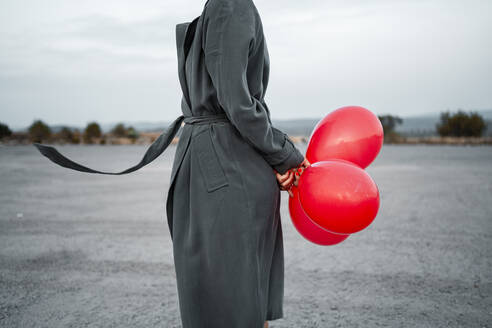 Mittlere erwachsene Frau mit Luftballon auf der Straße - RCPF01011