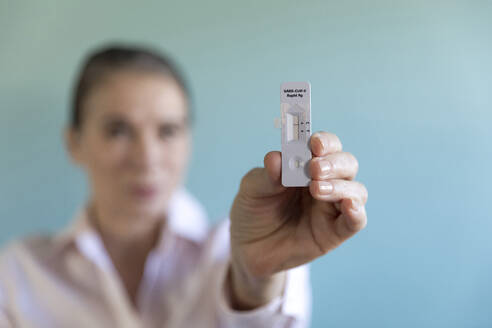 Woman holding Corona rapid test kit - FLLF00600