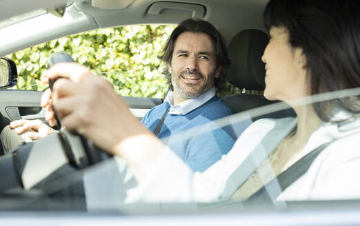 Business couple talking while sitting in car - JCCMF02085