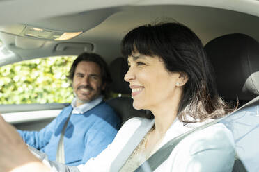 Smiling businesswoman traveling with man in car - JCCMF02086