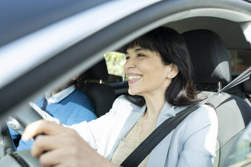 Smiling mature entrepreneur driving car - JCCMF02089