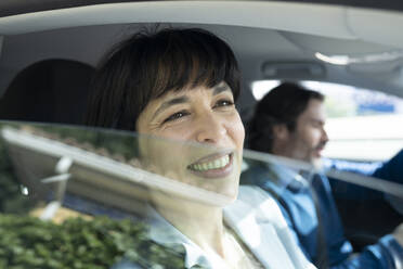 Smiling businesswoman looking through car window - JCCMF02095
