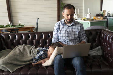 Sohn schläft bei Vater auf dem Sofa mit Laptop - OIPF00572