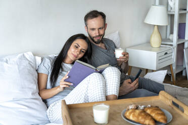 Mann und Frau frühstücken zu Hause auf dem Bett - OIPF00595