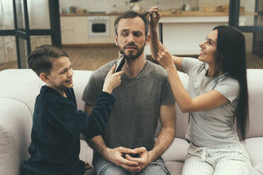 Familie schneidet einem Mann zu Hause die Haare - OIPF00619