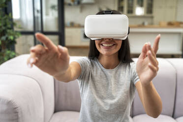 Frau mit Virtual-Reality-Headset im heimischen Wohnzimmer - OIPF00622