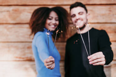 Young man and woman holding sparkler - EBBF03404