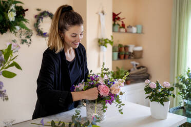 Female florist making flower arrangement at workshop - MPPF01717