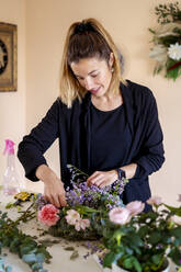 Female florist making flower arrangement at workshop - MPPF01723