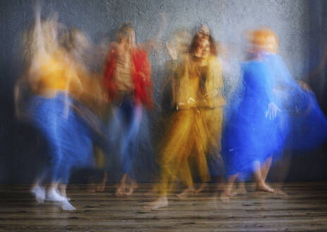 Frauen in buntem Kleid tanzen auf dem Boden im Studio - AZF00308