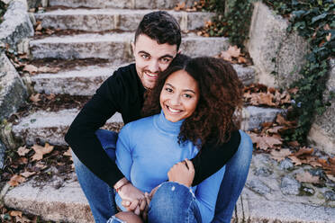 Junges Paar sitzt zusammen auf einer Treppe - EBBF03412