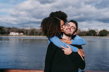 Girlfriend kissing while embracing boyfriend from behind - EBBF03422