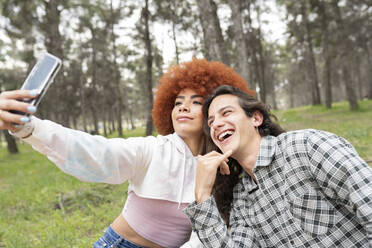 Mann macht Selfie mit junger Frau bei Party im Wald - JCCMF02132