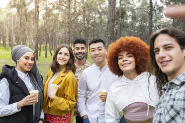 Multi-ethnische männliche und weibliche Freunde nehmen Selfie beim Genießen im Wald - JCCMF02143