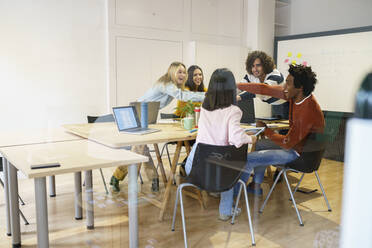 Happy multi-ethnic business colleagues at conference table in office - JSMF02137