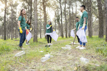 Umweltschützer stehen mit Plastikmüll im Wald - JCCMF02187