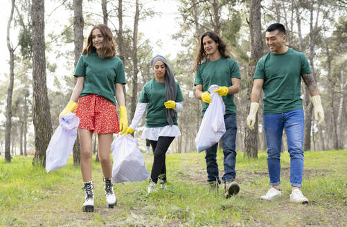 Umweltschützer gehen mit Plastikmüllsack im Wald spazieren - JCCMF02197