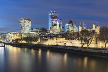 UK, England, London, Waterfront der City of London bei Nacht mit beleuchteten Wolkenkratzern und Tower of London im Hintergrund - AHF00388