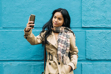 Langhaarige brünette asiatische Frau benutzt Handy auf der Straße - ADSF23707