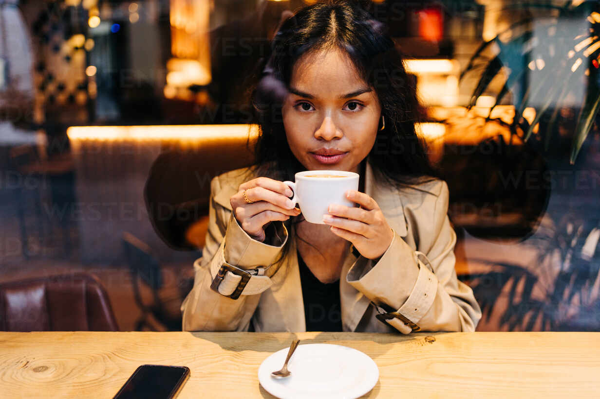 Langhaarige Brünette Asiatische Frau Die Einen Kaffee In Einem Café Trinkt Während Sie Ein