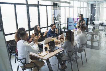 Multiethnische Gruppe von Unternehmern und Unternehmerinnen klatscht im Büro - SNF01304