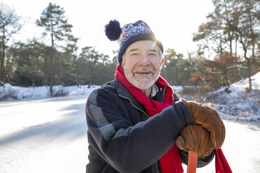 Mann mit Strickmütze im Schnee an einem sonnigen Tag - FVDF00126