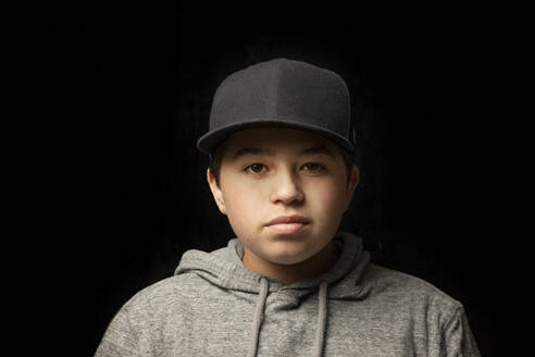 Boy wearing cap in front of black background - ISPF00073