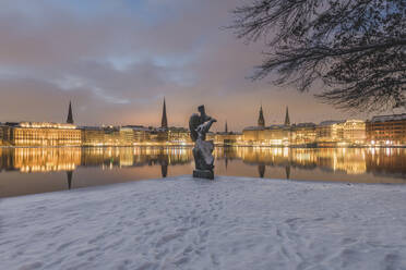 Deutschland, Hamburg, Beleuchtete Stadtarchitektur, die sich in der Binnenalster in der Abenddämmerung im Winter spiegelt - KEBF01874