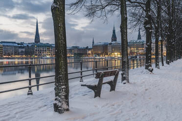 Deutschland, Hamburg, Beleuchtete Stadtarchitektur, die sich in der Binnenalster in der Abenddämmerung im Winter spiegelt - KEBF01875