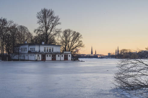 Deutschland, Hamburg, Gefrorene Außenalster in der Abenddämmerung im Winter - KEBF01890