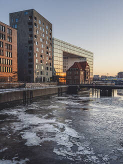 Deutschland, Hamburg, Gefrorenes Wasser des Brooktorhafens in der Abenddämmerung im Winter - KEBF01892