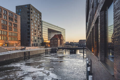 Deutschland, Hamburg, Gefrorenes Wasser des Brooktorhafens in der Abenddämmerung im Winter - KEBF01893