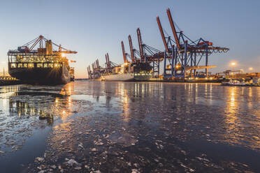 Germany, Hamburg, Waltershofer Hafen illuminated at dusk in winter - KEBF01894