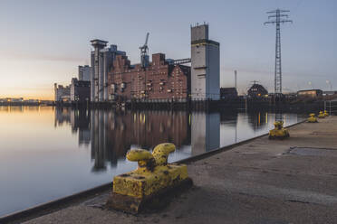 Deutschland, Hamburg, Rethespeicher spiegelt sich im Fluss bei Sonnenuntergang - KEBF01927