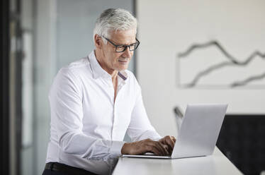 Reife Geschäftsfrau arbeitet am Laptop im Büro - RBF08112