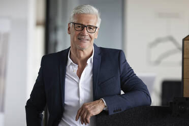 Älterer Berufstätiger mit Brille im Büro stehend - RBF08128