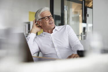 Thoughtful male entrepreneur looking away in office - RBF08153