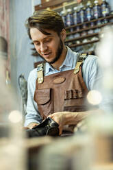 Male shoemaker repairing shoe at workshop - VGF00359