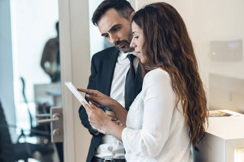 Businesswoman discussing with male professional in office - JSRF01524