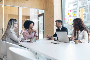 Männliche und weibliche Unternehmer diskutieren am Konferenztisch im Büro - JSRF01528