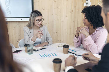 Unternehmerin diskutiert mit Kollegen bei einer Besprechung im Büro - JSRF01530