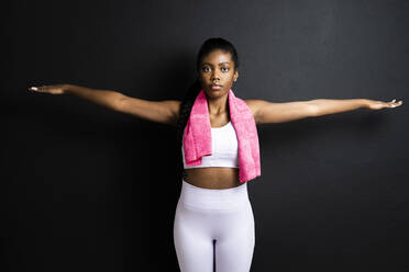 Body positive woman looking at the camera as she confidently embraces her  body, expressing self-love. Plus-size woman with curves and an athletic  physique stands in a studio wearing fitness clothing. stock photo