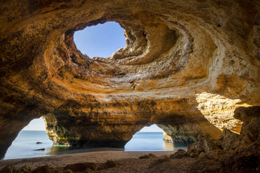 Blick auf die Benagil-Höhle mit Löchern am Ufer gegen den endlosen Ozean in der Algarve Portugal - ADSF23787