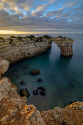 Von oben malerischer Blick auf hohe Felsformationen an der Meeresküste bei Sonnenuntergang in Praia da Abandeira, Algarve Portugal - ADSF23788